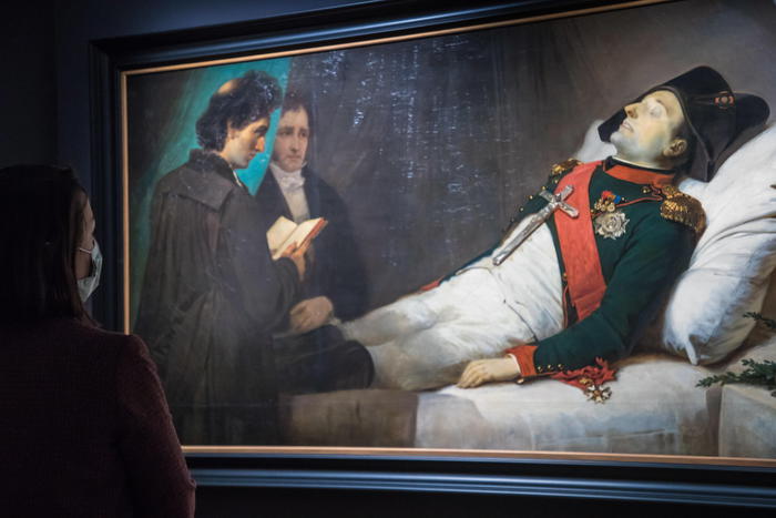 epa09120918 A visitor looks at the artwork 'Napoleon on his deathbed' by French painter Jean-Baptiste Mauzaisse on display during a press visit of the exhibition 'Napoleon N'Est Plus' (Napoleon is no more) hosted at the Musee de l'Armee (military museum) at the Hotel des Invalides in Paris, France, 07 April 2021. The exhibition is dedicated to the death and the legacy of Napoleon. Kept at Invalides, Napoleon Bonaparte's body lies under a dome within six separate coffins. France is preparing for the celebrations of the bicentennial of the death of French military and political leader Napoleon Bonaparte (1769-1821) who died in exile on the island of Sainte Helena on 05 May 1821. The official commemorations of the bicentenary of his death are causing controversy in France among those considering that he represents a dark part of the country's history and those who support its legacy.  EPA/CHRISTOPHE PETIT TESSON