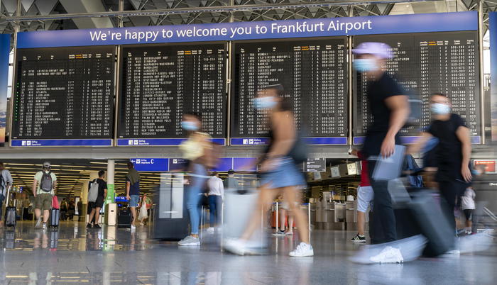 epa08606885 Passengers walk past a board displaying information on flights departure at the international airport in Frankfurt am Main, Germany, 16 August 2020. Starting 08 August, the German government has made compulsory coronavirus disease (COVID-19) testing for people returning from risk countries amid a rise of infections. Germany has a large list of high-risk countries that is constantly updated and most recently it added several parts of Romania, along with Spain and Bulgaria to it.  EPA/RONALD WITTEK