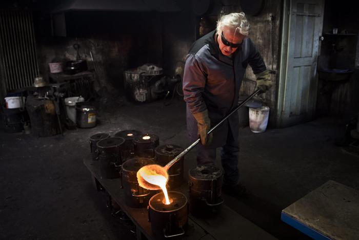 epa05695848 Serge Serge Huguenin founds a bell in his foundry 'Fonderie Blondeau' in Chaux-de-Fonds, canton of Neuchatel, Switzerland, 03 January 2017. The 'Fonderie Blondeau' is specialized in the making of the traditional Swiss bells.  EPA/JEAN-CHRISTOPHE BOTT