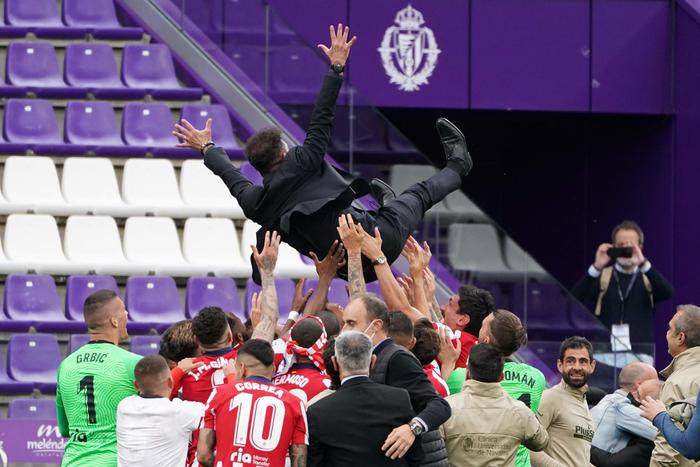 Atletico MadridÂ´s players toss Atletico Madrid's Argentine coach Diego Simeone after winning the Spanish league football match against Real Valladolid FC and the Liga Championship title at the Jose Zorilla stadium in Valladolid on May 22, 2021. (Photo by CESAR MANSO / AFP)