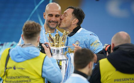 epa09223975 Manchester City's manager Pep Guardiola recieves a kiss during the Premier League trophy presentation after the English Premier League soccer match between Manchester City and Everton FC in Manchester, Britain, 23 May 2021.  EPA/Dave Thompson / POOL EDITORIAL USE ONLY. No use with unauthorized audio, video, data, fixture lists, club/league logos or 'live' services. Online in-match use limited to 120 images, no video emulation. No use in betting, games or single club/league/player publications.