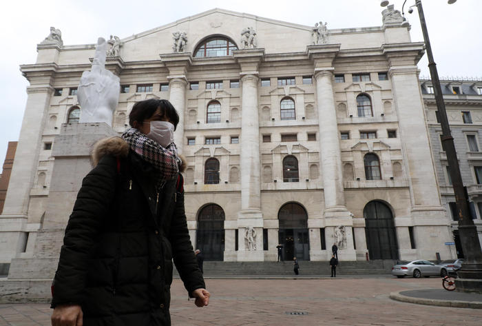 A woman wearing a protective face mask walks at Piazza Affari where Palazzo Mezzanotte, headquarters of the Italian Stock Exchange, is located, in Milan, Italy, 25 February 2020. So far seven people with the coronavirus have died in Italy - all of them over 60 and several with pre-existing conditions.
ANSA / MATTEO BAZZI