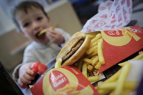 epa06506141 A three-year-old child eats Hamburger and fries in a Quick fast food restaurant in Namur, Belgium, 08 February 2018. The Indian government on 08 February 2018 said there was no proposal at present to ban advertisements of junk food on television. Minister of State for Information and Broadcasting Rajyavardhan Singh Rathore told the Parliament that bodies like the Food and Beverage Alliance of India have already decided to voluntarily restrict food and beverage advertisements concerning children.  EPA/OLIVIER HOSLET