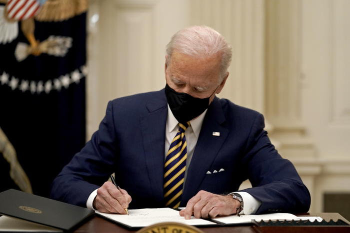 US President Joe Biden signs two executive orders after delivering remarks on his administration's response to the economic crisis in the State Dining Room of the White House in Washington, DC, USA, 22 January 2021.  ANSA/Ken Cedeno / POOL