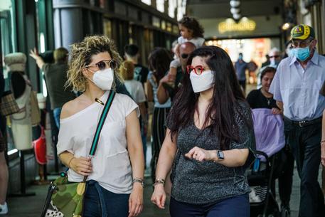 Due persone con il volto coperto da unaa mascherina passeggiano nelle vie del centro, Torino, 26 maggio 2020. ANSA/TINO ROMANO