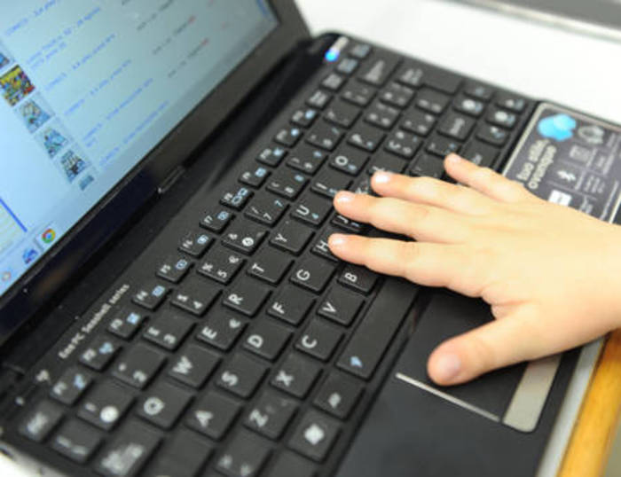 Una bambina usa la tastiera di un computer collegato a internet, Pisa, 23 giugno 2011. ANSA / FRANCO SILVI
