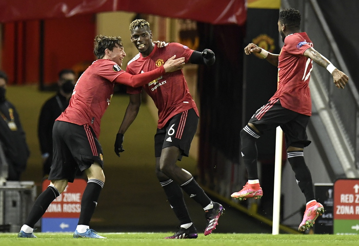 epa09168649 Paul Pogba (C) of Manchester United celebrates with teammate Victor Lindelof (L) after scoring the 5-2 lead during the UEFA Europa League semi final, first leg soccer match between Manchester United and AS Roma at Old Trafford in Manchester, Britain, 29 April 2021.  EPA/PETER POWELL