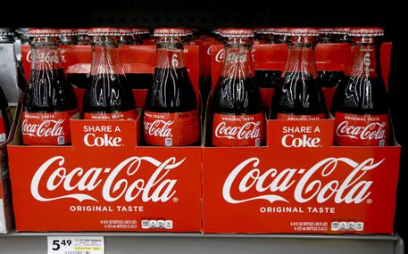 FILE--In this Aug. 8, 2018, file photo, bottles of Coca Cola sit on a shelf in a market in Pittsburgh. The Coca-Cola Company says that it's 