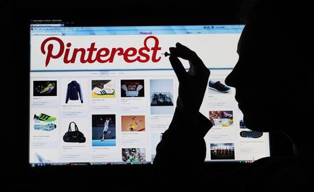 epa03155777 An illustration dated 23 March 2012 shows a woman holding a pin to a computer screen that shows the website of photo-sharing network Pinterest in Hanover, Germany. One mouse-click puts pictures up to a virtual wall. More and more users engage in the social network Pinterest.  EPA/JULIANÂ STRATENSCHULTE