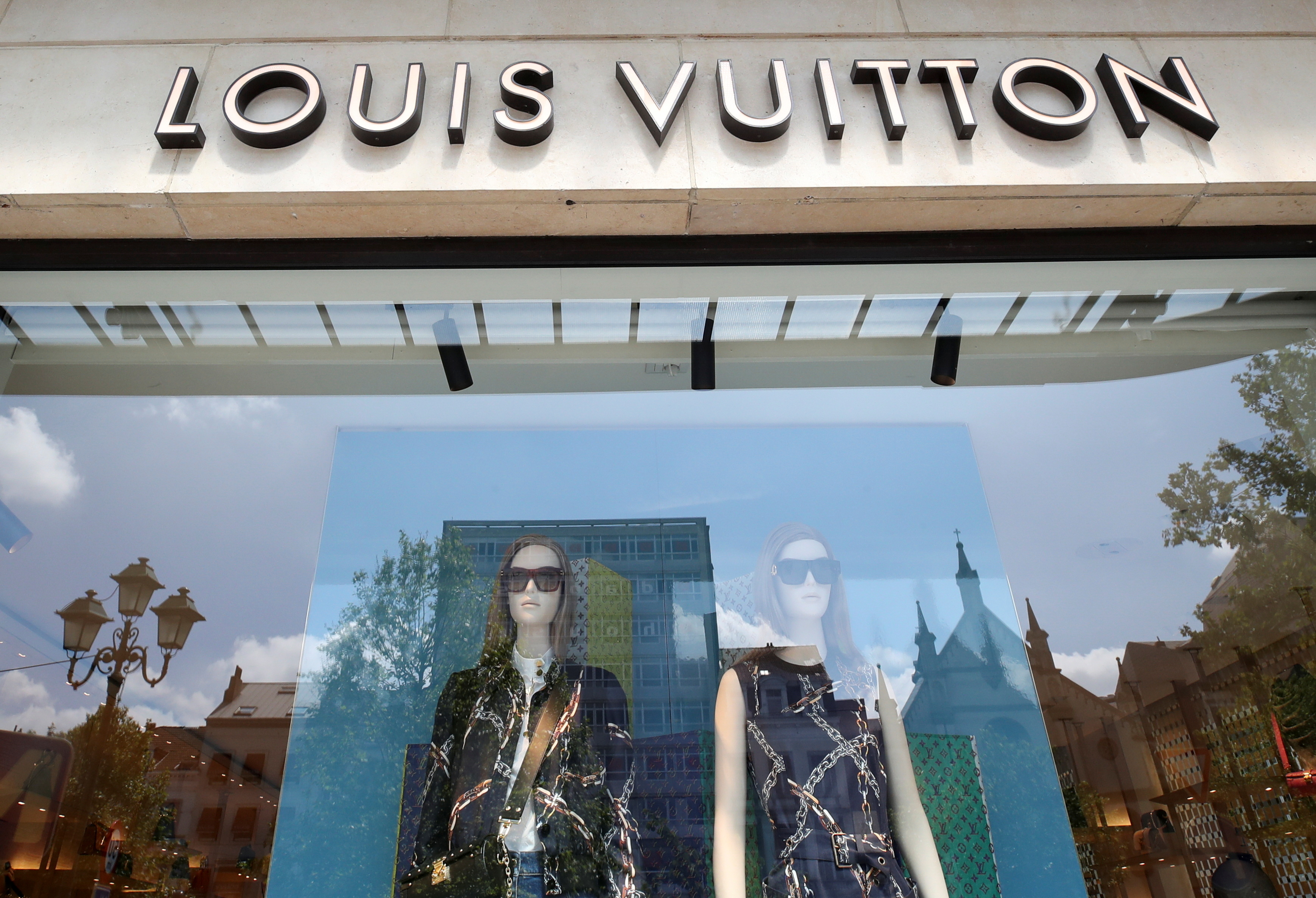 FILE PHOTO: A logo of  luxury goods company Louis Vuitton is seen at the entrance of a shop in Brussels, Belgium July 2, 2021. REUTERS/Yves Herman