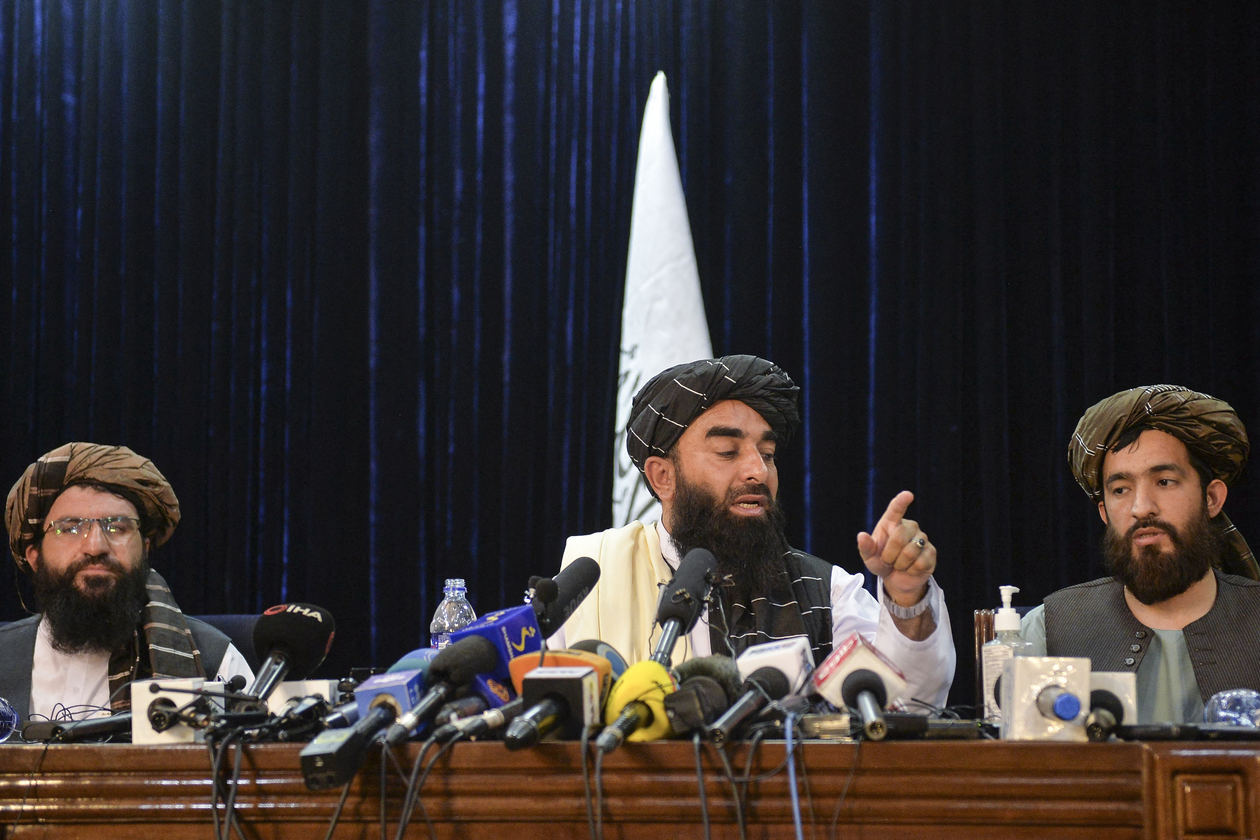 Taliban spokesperson Zabihullah Mujahid (C) gestures as he addresses the first press conference in Kabul on August 17, 2021 following the Taliban stunning takeover of Afghanistan. (Photo by Hoshang Hashimi / AFP)