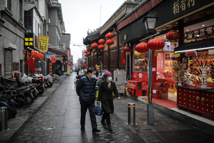 epa09041913 People wearing protective face masks walk at Qianmen commercial street amid coronavirus pandemic in Beijing, China, 28 February 2021. China's economy grew by 2.3 per cent year-on-year in 2020, as the country's gross domestic product stood at 101.6 trillion yuan (12.98 trillion euros) last year, according to the National Bureau of Statistics.  EPA/WU HONG