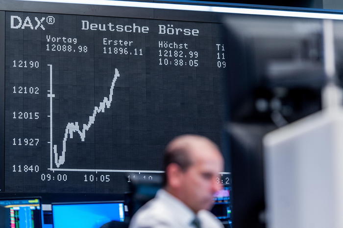 epa08797905 An electronic display shows the DAX chart, as a trader works in front of her computer screens at the trading floor of the Deutsche Boerse stock exchange, the morning following the US Presidential Election, in Frankfurt/Main, Germany, 04 November 2020. The German stock index DAX opened weakly but rebounded quickly despite inconclusive news about the outcome of the US elections.  EPA/MAXIMILIAN VON LACHNER