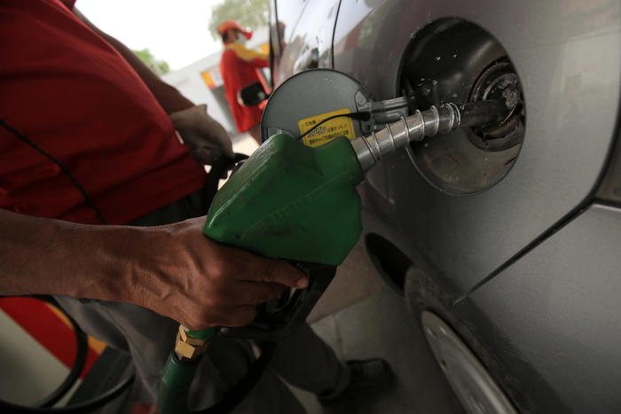 epa09276076 A gas station attendant fills a car in Peshawar, Pakistan, 16 June 2021. The Pakistani government on 16 June increased fuel prices, raising the petrol price to Rs 111.22 (0.71 US dollar) per liter, while approving the recommendations made by the Oil and Gas Regulatory Authority (Ogra).  EPA/ARSHAD ARBAB