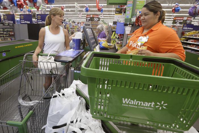 In this June 4, 2015 photo, a shopper checks out at a Wal-Mart Neighborhood Market store in Bentonville, Ark. The Federal Reserve on Wednesday, Oct. 14, 2015 said steady consumer spending and an improving housing market spurred modest U.S. economic growth in the late summer, though factory output was sluggish in part because of the strong dollar. (ANSA/AP Photo/Danny Johnston)