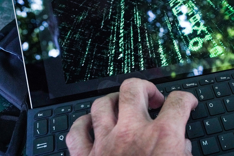 Una ricostruzione di un hacker con il suo computer che tenta di entrare in un sito. Torino 20 luglio 2021 ANSA/TINO ROMANO