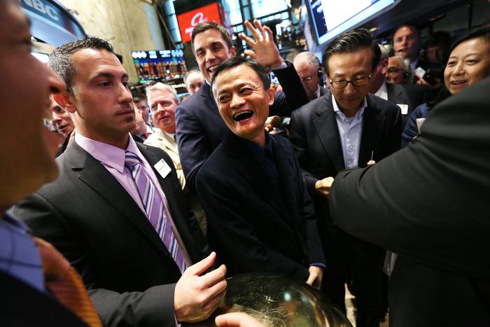 epa04407772 Jack Ma (C), the founder and executive chairman of Alibaba, smiles while on the floor of the New York Stock Exchange (NYSE) during the first trading of shares in the Chinese company's initial public offering in New York, New York, USA, 19 September 2014. Alibaba, an online commerce company based in China, has an initial market value of 168 billion US dollars, and the IPO is expected to be one of the largest ever.  EPA/JUSTIN LANE
