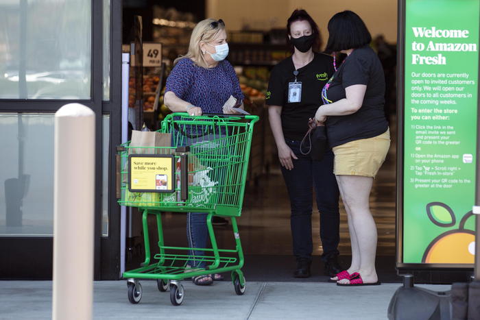 epa08632974 Customers leave the Amazon Fresh supermarket in Woodland Hills, California, USA, 28 August 2020. On 26 August, Amazon Fresh opened its first store in the USA.  EPA/ETIENNE LAURENT