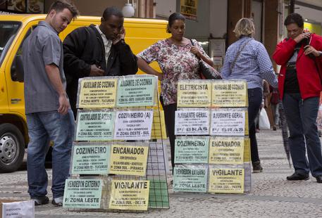 In this Tuesday, Aug. 25, 2015 photo, people look at job postings in downtown Sao Paulo, Brazil.  With an economy in recession, along with growing inflation and unemployment, President Dilma Rousseff has the worst approval rating for any president since Brazils return to democracy. (ANSA/AP Photo/Andre Penner)