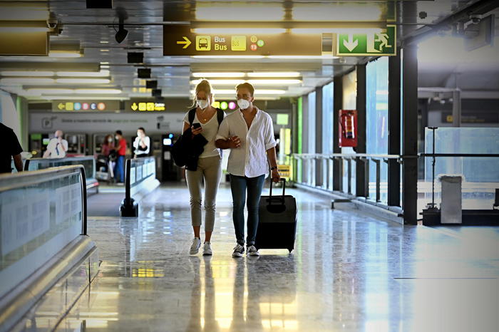 epa08581795 A couple walks with their luggage at the International Barajas Airport in Madrid, Spain, 03 August 2020. The Airport remains almost empty due to the coronavirus crisis in the tourism sector. According to the National Stadistic Institute, the arrivals of foreing tourists have fallen a 97,7 percent in June compared to the same month of 2019. This month 204,926 tourists come to Spain.  EPA/FERNANDO VILLAR