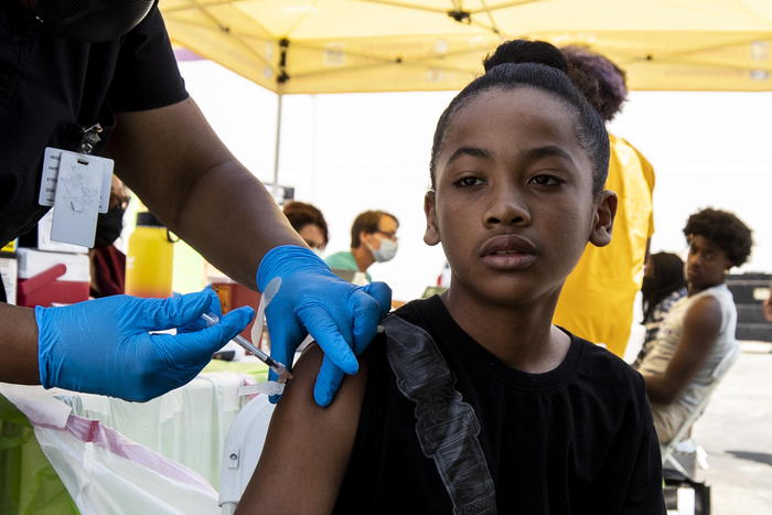 epa09349479 Future, 12 year-old, gets vaccinated against Covid-19 at a mobile COVID-19 vaccine clinic organized by Mothers In Action in Crenshaw, South of Los Angeles, California, USA, 16 July 2021. Starting Saturday night, Los Angeles County will require the return to wearing mask indoor amid alarming surge in the number of coronavirus cases linked to the Delta variant. The past week Los Angeles has seen an average of about a thousand new cases a day, and yesterday a spike to more than 1500 new cases, as well as an increase in hospitalizations.  EPA/ETIENNE LAURENT