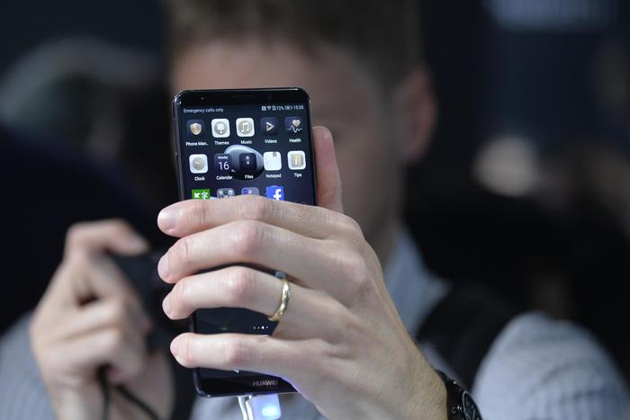 epa06269517 An attendee tries out the new Huawei Mate 10 Pro during the official launch event for the Huawei Mate 10 smartphone series in Munich, southern Germany, 16 October 2017. The chinese manufacturer's new offering is aimed at the luxury market.  EPA/PHILIPP GUELLAND