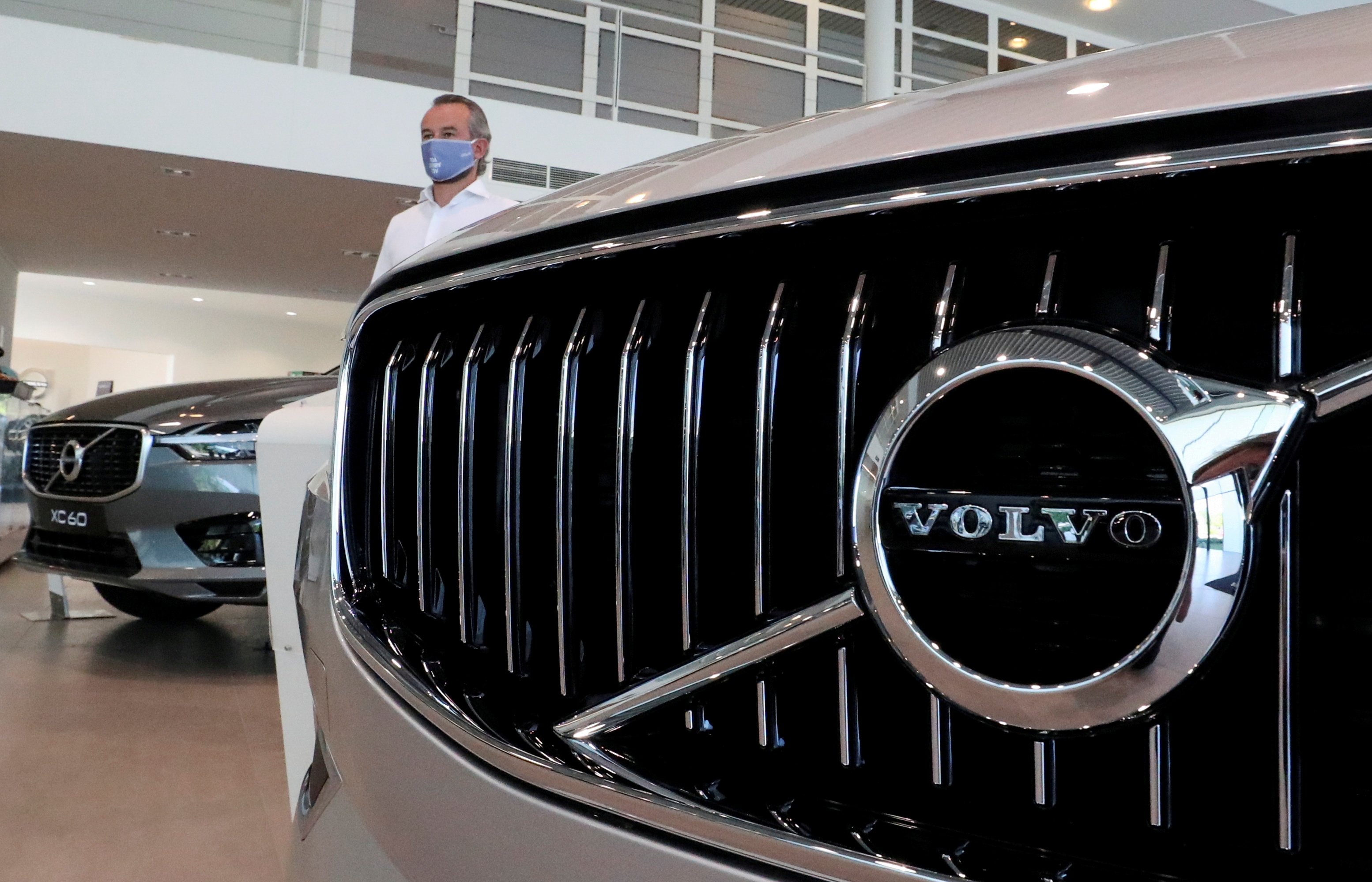 FILE PHOTO: An employee at a Volvo car dealer, wearing a protective mask is seen in a showroom, in Brussels, Belgium, May 28, 2020. REUTERS/Yves Herman/File Photo