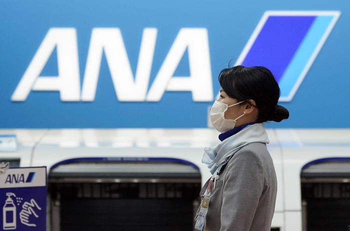 epa09169333 An All Nippon Airways (ANA) staff member wears a protective face mask at Haneda Airport in Tokyo, Japan, 30 April 2021. ANA announced a record net loss of 3.7 billion USD for the fiscal year 2020 due to the pandemic that directly hit the travel industry.  EPA/FRANCK ROBICHON