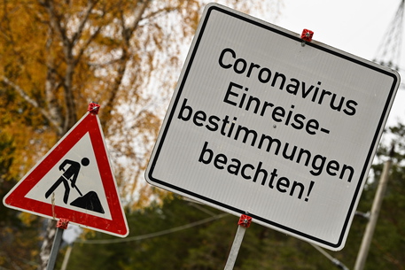 epa09587202 A sign informs about Corona travel regulations near a border crossing in Scharnitz, Austria, 17 November 2021. In its efforts to halt the rapid rise of COVID-19 infections, Austria's government imposed strict travel restrictions mandating travelers to be either fully vaccinated, recovered from the disease or provide a negative PCR test upon entry.  EPA/PHILIPP GUELLAND