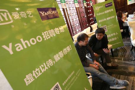 epa04669276 A former employee of the Yahoo research and development office talks with a human resource manager from other internet company to look for job opportunities at a special job fair for former Yahoo employees in Beijing, China, 19 March 2015. Yahoo has announced to close its Beijing research and development office in China in a new cost-cutting move on 18 March 2015 that eliminate 200 to 300 jobs, according to media reports.  EPA/WU HONG