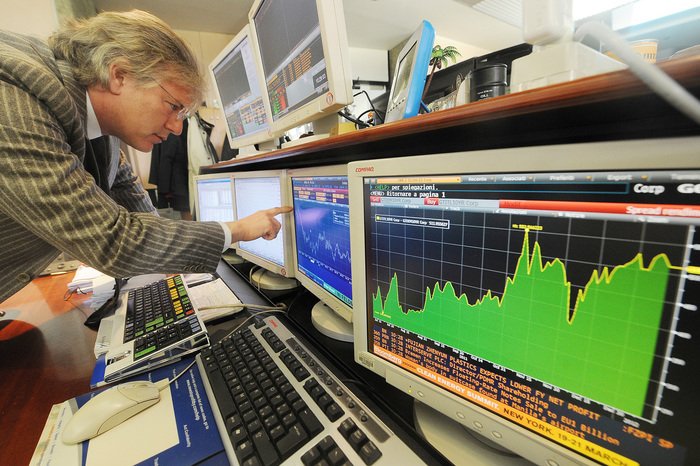 Un operatore finanziario di Milano osserva l'andamento del mercto su alcuni schermi, 11 gennaio 2012. 
ANSA/DANIEL DAL ZENNARO