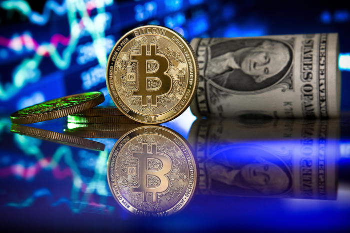 epa08957195 (FILE) - A bitcoin in front of a monitor showing a stock barometer in Duesseldorf, Germany, 20 January 2021 (reissued 22 January 2021). Media reports 22 January 2021 state cryptocurrency Bitcoin's value on 22 January 2020 dropped down to 28,000 USD in early trading in Asia, but rose back to almost 32,000 USD. In total, the cryptocurrency has lost 11 per cent in value during week.  EPA/SASCHA STEINBACH
