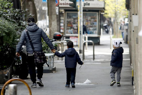 Genitori a passeggio con i figli a Milano, 1 aprile 2020. ANSA/Mourad Balti Touati