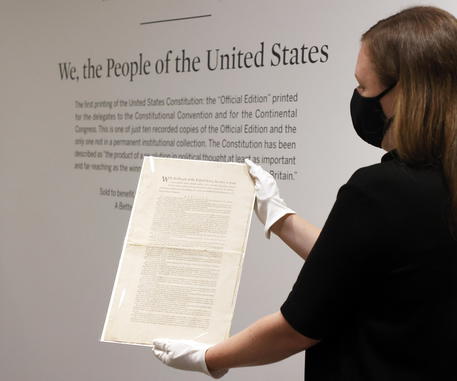 epa09473326 A specialist in books and manuscripts at Sotheby's holds a printed copy of the 1787 U.S. Constitution during a preview of an upcoming auction at Sotheby's in New York, New York, USA, 17 September 2021. The historical document is expected to sell for an estimated 15-20 Million USD in November. The auction is to coincide with Constitution Day, 234 years since America's Founding Fathers signed the country's significant document. It is also the only copy of the first printing of the Constitution that remains in private hands.  EPA/JASON SZENES