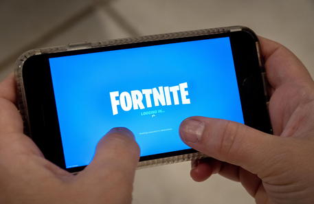epa08621882 A person plays Fortnite on an iPhone in Miami, Florida, USA, 24 August 2020. US tech giant Apple and game developer Epic Games are in a dispute over the distribution of income from in-app purchases of the game Fortnite.  EPA/CRISTOBAL HERRERA-ULASHKEVICH