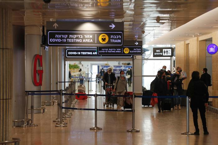 Passengers arrive to Israel's Ben Gurion Airport in Lod, east of Tel Aviv, on November 28, 2021. - Israel is to close its borders to all foreigners on November 28, 2021 in a bid to stem the spread of the new Omicron variant of the coronavirus, authorities said. The government's latest announcement came just hours before the start at sundown of the eight-day-long Jewish holiday of Hanukkah, the Festival of Lights. (Photo by Ahmad GHARABLI / AFP)