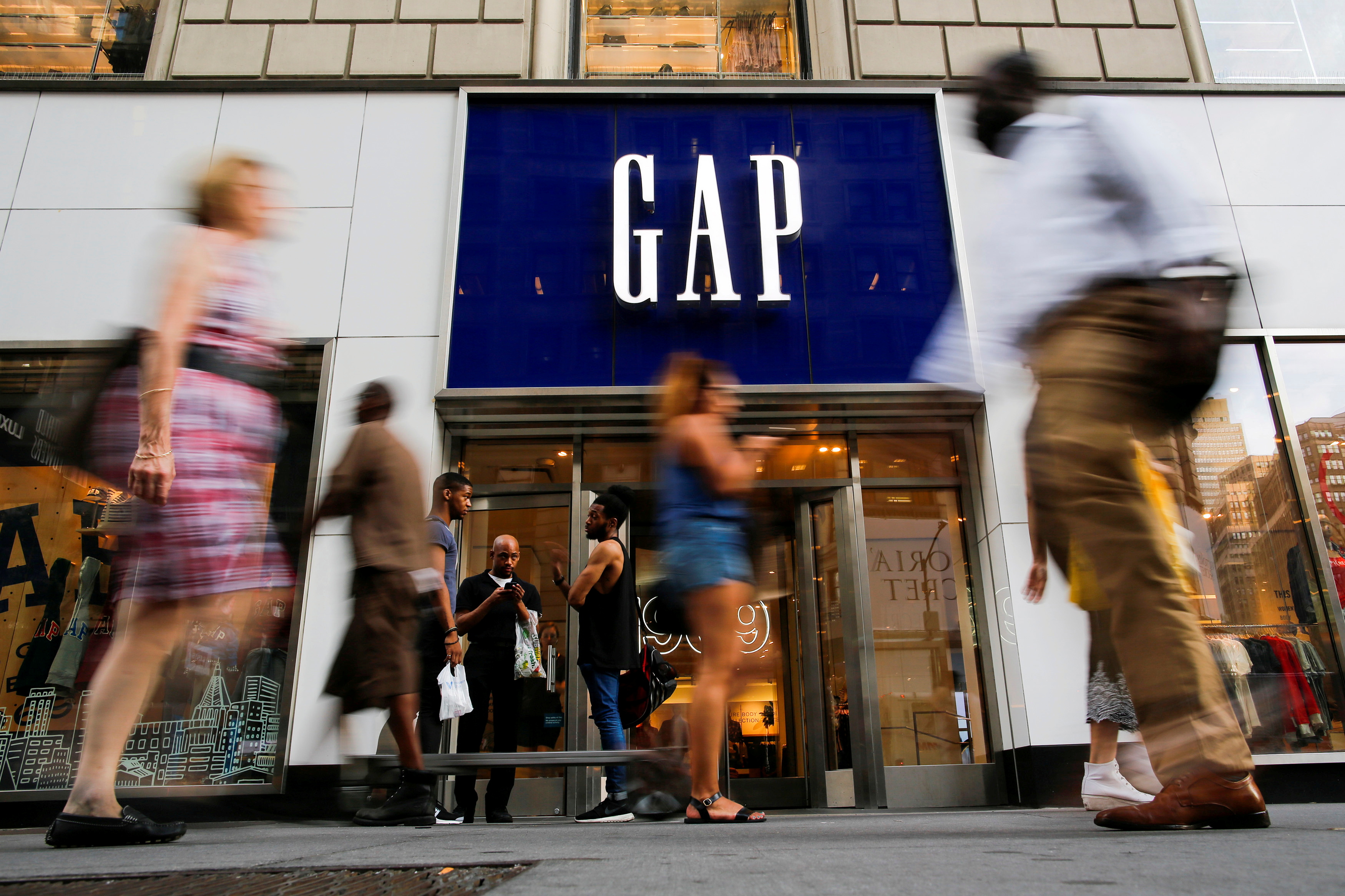 FILE PHOTO: People pass by the GAP clothing retail store in Manhattan, New York, U.S., August 15, 2016. REUTERS/Eduardo Munoz