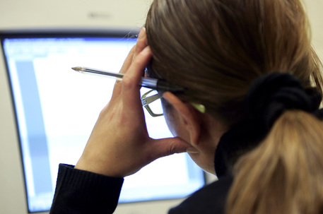 Un'impiegata davanti allo schermo del computer nel suo ufficio durante l'orario di lavoro in una foto di archivio. ANSA/ FILIPPO MONTEFORTE