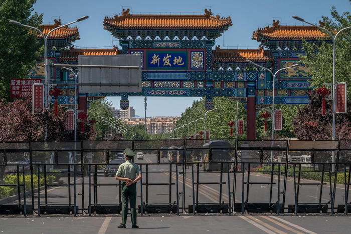 epa08484450 A paramilitary police officer stands guard at the entrance to the closed Xinfadi market, in Fengtai district, Beijing, China, 14 June 2020. One of Beijing's largest markets, Xinfadi in Fengtai district, was shut down on 13 June, and the district placed under lockdown following the confirmation of new domestic coronavirus cases which were linked to the Xinfadi market.  EPA/ROMAN PILIPEY
