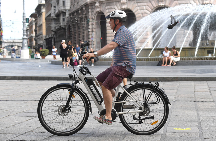 Un uomo con la sua bici eletrica in giro per la citta'. Genova, 31 luglio 2019.