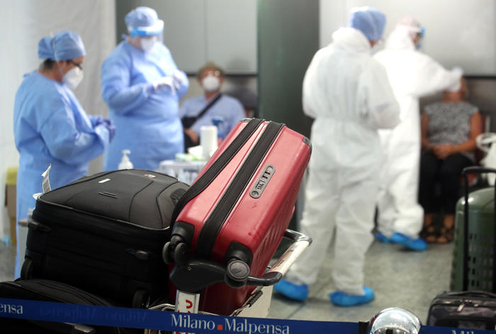 Health workers collect swabs and conduct tests on passengers for coronavirus disease (COVID-19) positivity at the Malpensa airport in Milan, Italy, 20 August 2020.