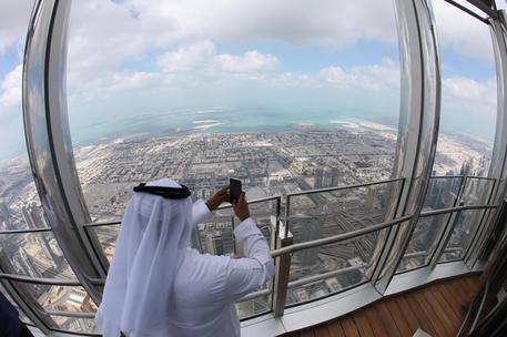epa07366683 A picture taken with a fish eye lens shows UAE man taking photo from the new highest lounge in the world at Burj Khalifa in Dubai, United Arab Emirates, 13 February 2019. Ahmad Al Falasi, Executive Director Emaar Properties announced during media briefing the opening of highest lounge in the world at Burj Khalifa which is located at 152, 153 and 154 floor which have distinctive settings each assuring never before seen views of the city.  EPA/ALI HAIDER