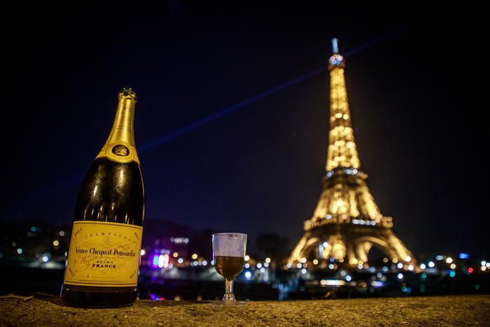 epa08913366 A bottle and a glass of champagne left in front of the Eiffel Tower during the New Year eve, in Paris, France, 01 January 2021. Security measures have been stepped up across France to restrain celebrations or streets gathering due to the still high number of Covid-19 cases, a curfew is imposed between 8 pm and 6 am effective from 15 December 2020.  EPA/CHRISTOPHE PETIT TESSON