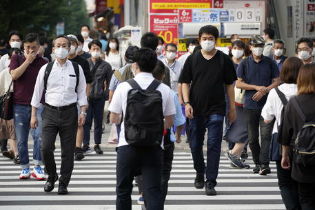 epa08576804 Pedestrians wearing masks cross a street in Akihabara district in Tokyo, Japan, 31 July 2020. The Tokyo Metropolitan Government announced record 463 new cases of COVID-19 infections in the Japanese capital.  EPA/FRANCK ROBICHON