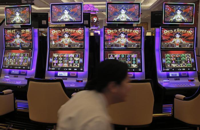 A worker walks past slot machines at the new expansion of the Galaxy Macau casino resort in Macau, Tuesday, May 26, 2015. Macau, the worlds casino capital, is launching a new wave of resort expansion this week with the first of more than $20 billion in projects to open on the up-and-coming Cotai Peninsula. (ANSA/AP Photo/Vincent Yu)