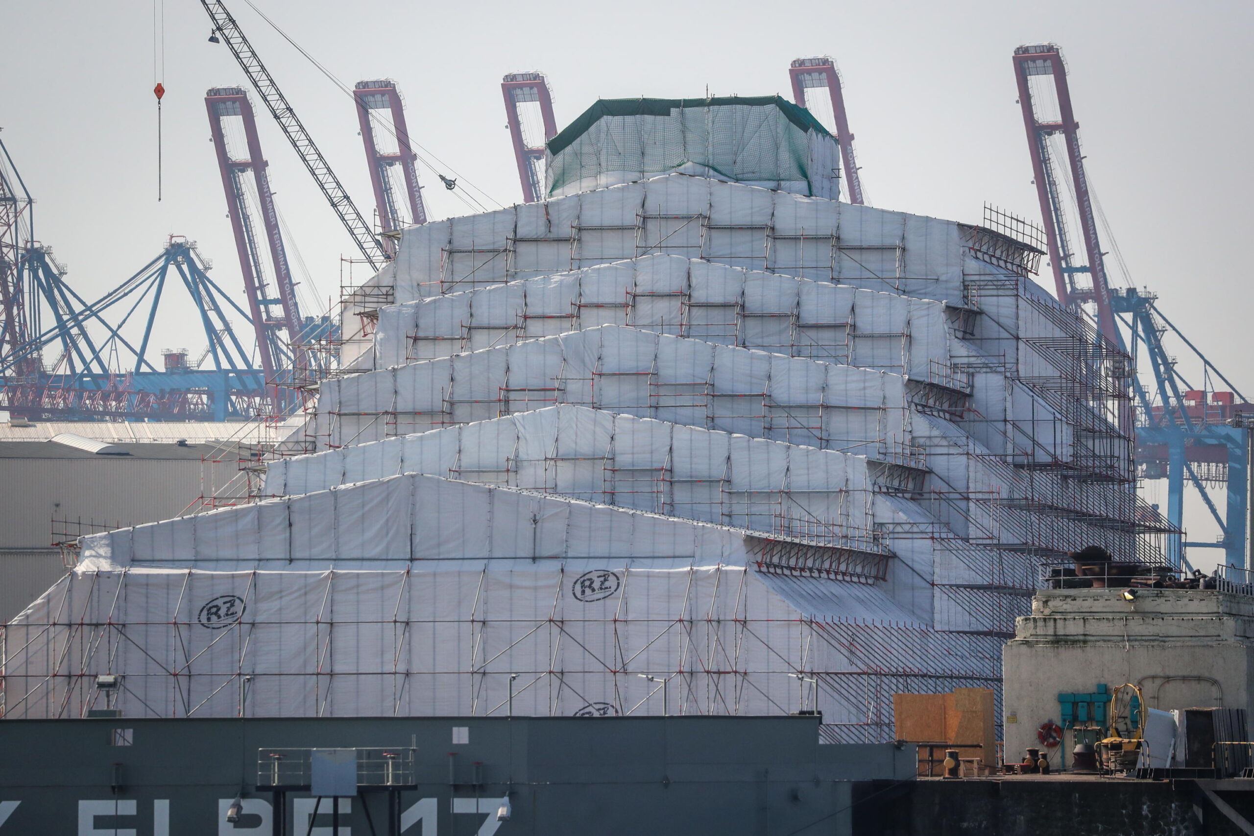 epa09844448 The mega yacht Dilbar, probably owned by Alisher Usmanow, sits covered with tarps inside a dry dock at Blohm + Voss shipyards in Hamburg, northern Germany, 23 March 2022. Blohm + Voss belongs to the Bremen based Luerssen Group and specializes in the construction and maintenance of luxury yachts and military ships.  EPA/FOCKE STRANGMANN
