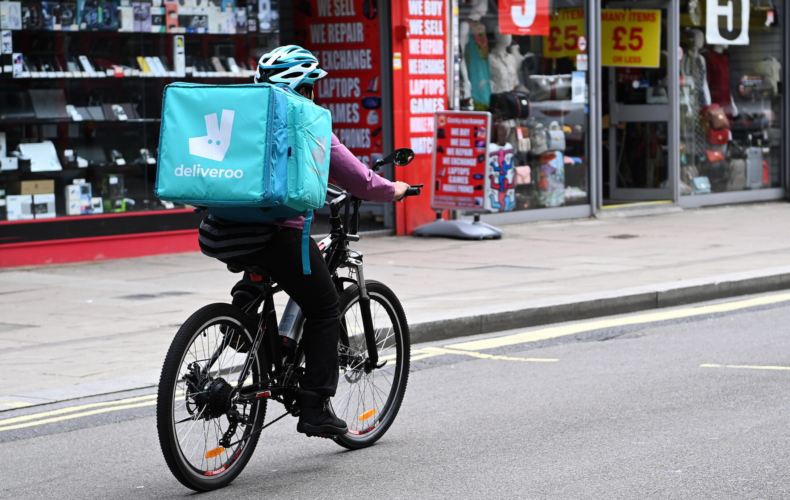 epa09385610 A Deliveroo food courier at work in London, Britain, 01 August 2021. The UK government is hoping to entice young people to get Covid-19 vaccinations with various discounts including Uber and Deliveroo food discounts. The UK's vaccination program has begun to slow down as not enough young people are getting jabbed.  EPA/ANDY RAIN