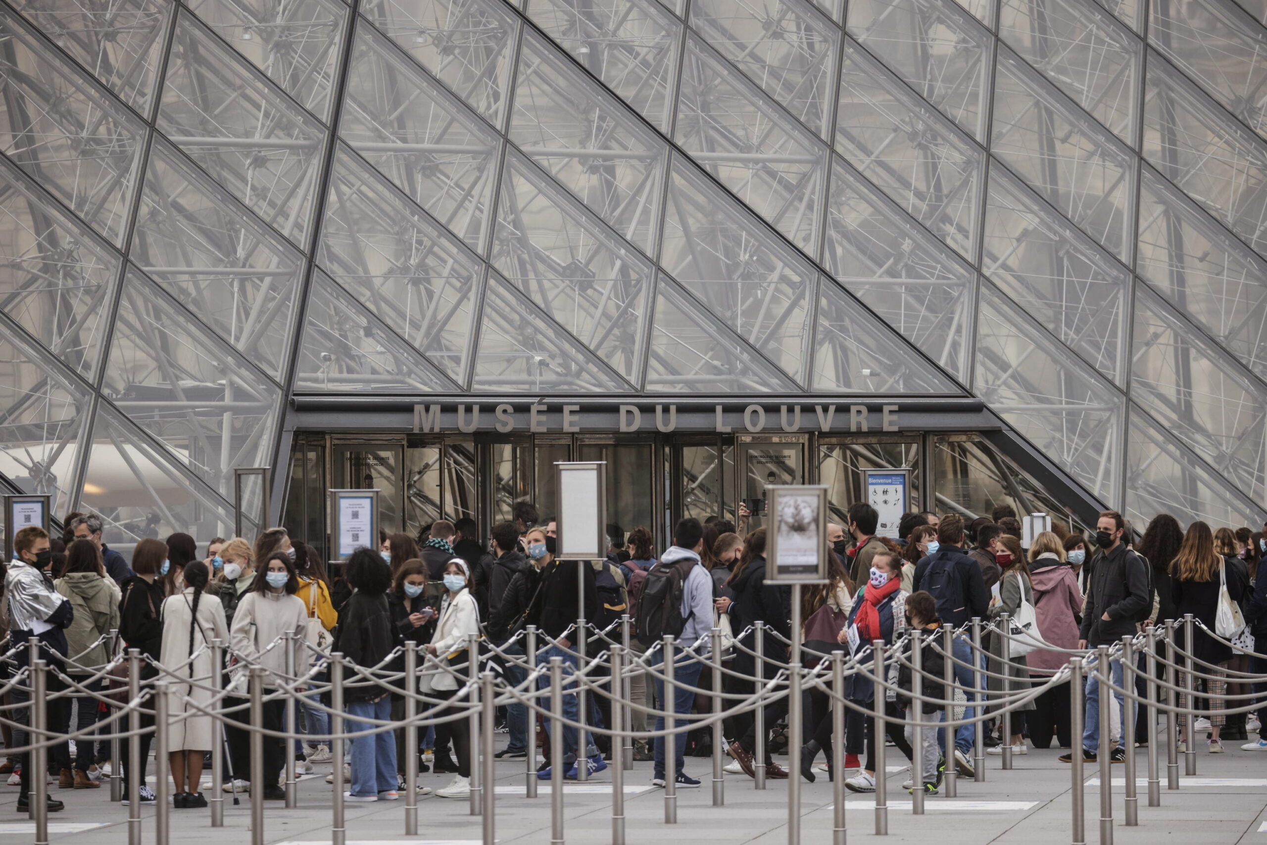epa09211467 Visitors queue outside the Louvre Museum on its reopening day, in Paris, France, 19 May 2021. France eased some of its coronavirus disease (COVID-19) restrictions starting on 19 May, allowing cultural place, cinema, restaurants and cafes to admit customers outdoors, as pressure on hospitals and intensive care units in the country is diminishing. EPA/YOAN VALAT