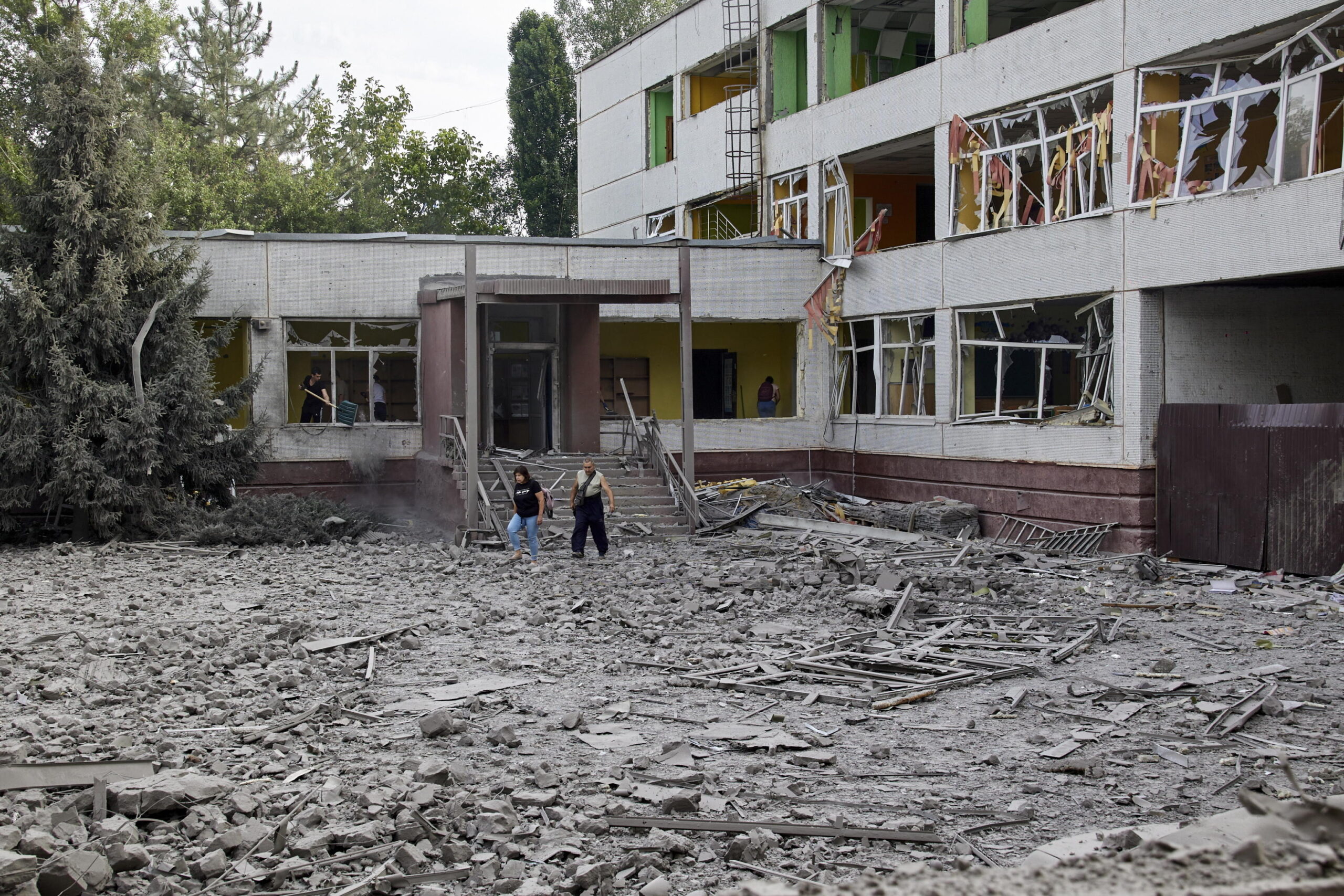 epa10063827 Locals clean the debris at a damaged school following a Russian rocket strike hitting the city of Kharkiv, Ukraine, 10 July 2022. Nobody was injured there. Kharkiv and surrounding areas have seen increased shelling and airstrikes from Russian forces. Russian troops on 24 February entered Ukrainian territory, starting a conflict that has provoked destruction and a humanitarian crisis. EPA/SERGEY KOZLOV