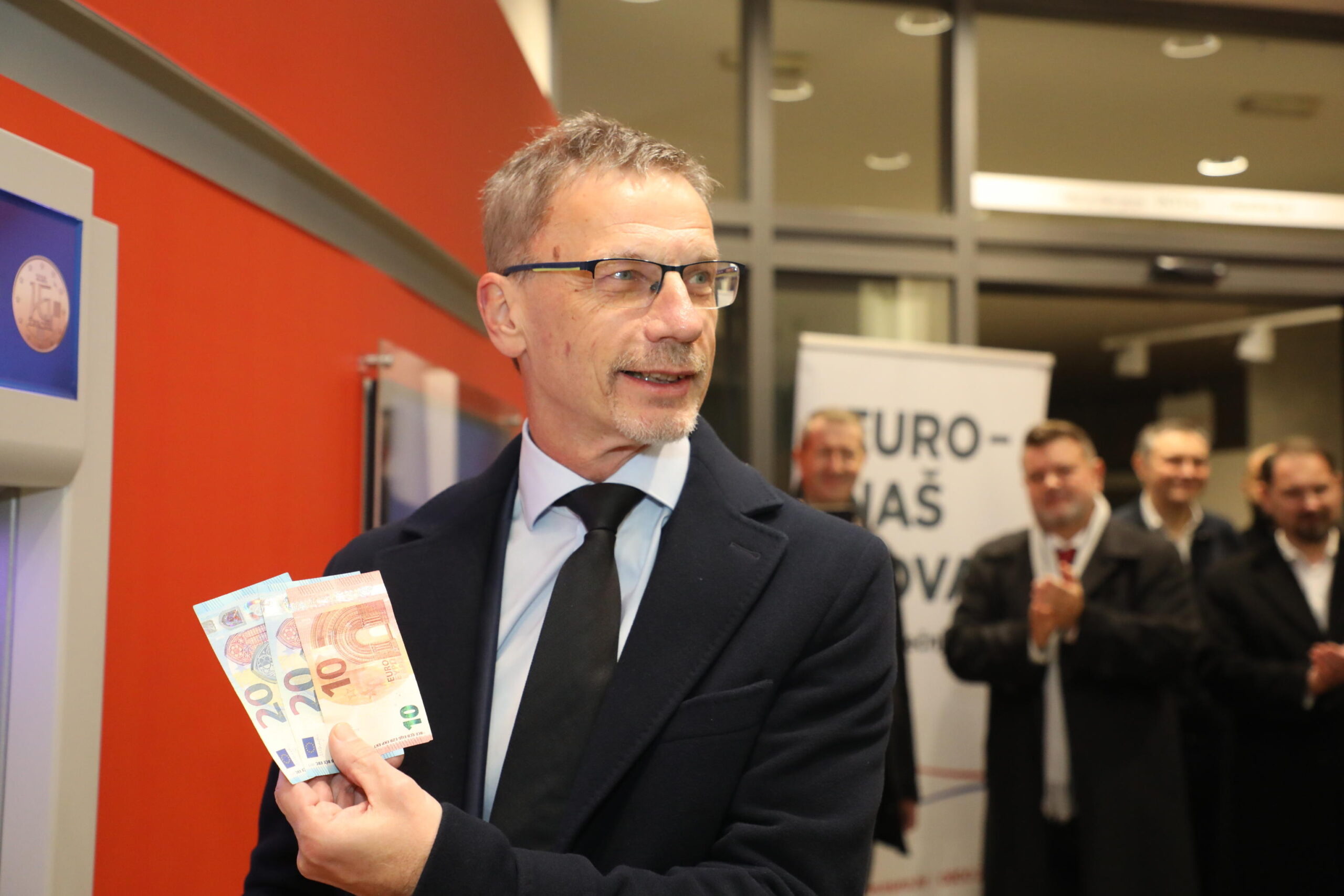 epa10384633 Croatian National Bank Governor Boris Vujcic  takes the first euro banknotes at ATM in Zagreb, Croatia, 01 January 2023. From 01 January 2023 Croatia entered into the Eurozone and Schengen area.  EPA/LANA SLIVAR / POOL